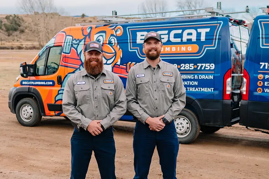 Big Cat Plumbing, Heating, and Cooling technicians in front of fleet vans in Colorado Springs, CO.