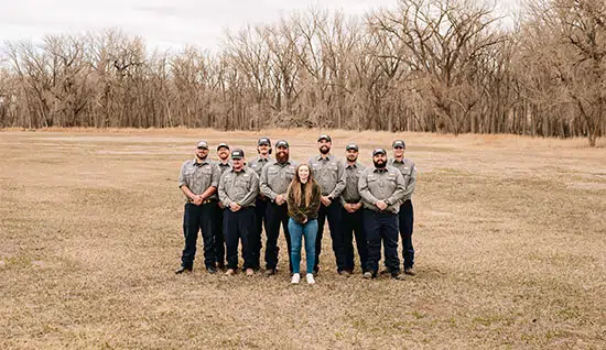 group photo of some of the Big Cat team, in front of a forest