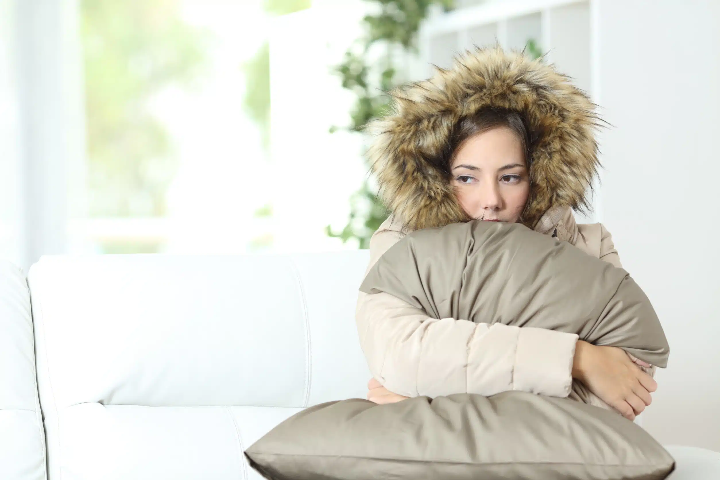 woman wearing jacket inside because heater is broken