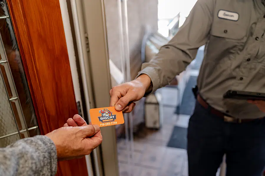 Technician handing customer business card in Colorado Springs, CO.