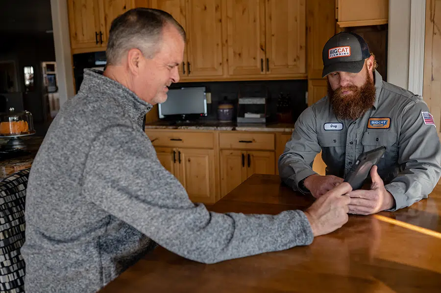 Technician helping customer at dining room table in Colorado Springs, CO.