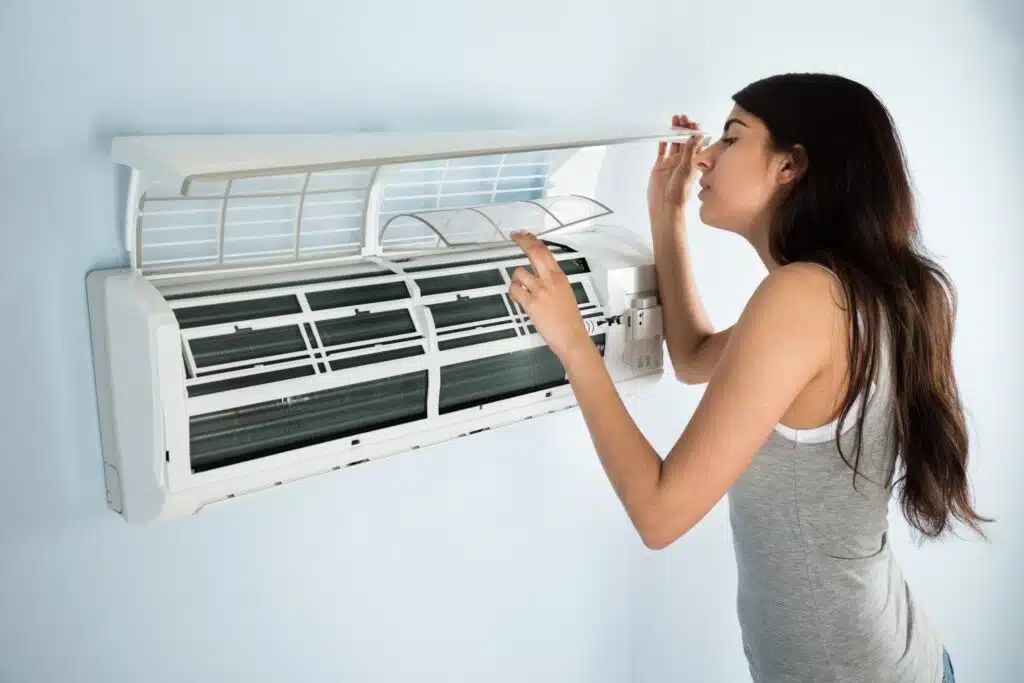 woman checking broken AC in Colorado Springs