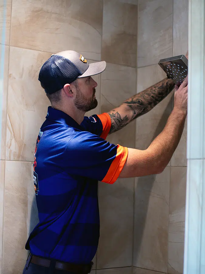 Big Cat plumber working on shower