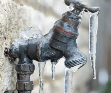 outdoor faucet frozen with icicles