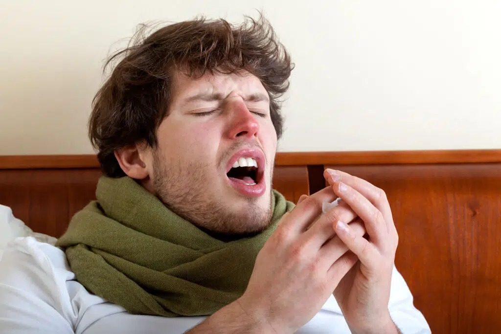 man sneezing due to poor indoor air quality