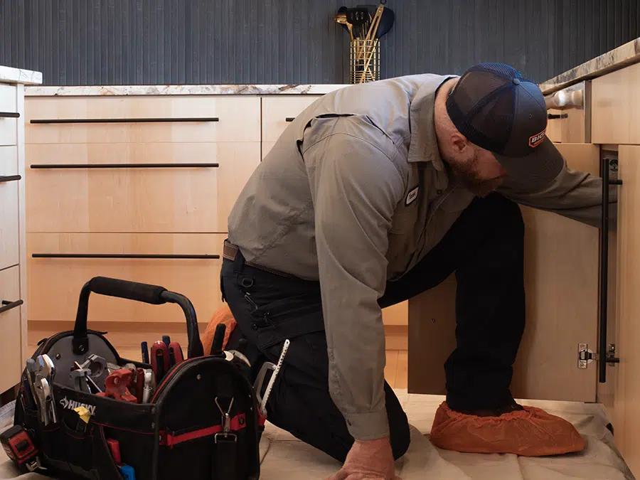 Big Cat plumber working under sink